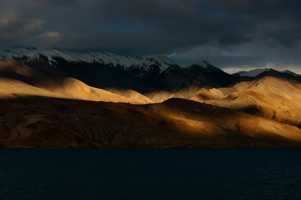 Mountain peaks rising above the shoreline of Pangong Lake